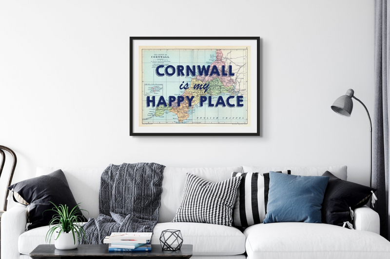 framed cornwall map print above grey sofa in living room. Blue typography of cornwall is my happy place over the cornwall map