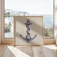 Framed artwork of an anchor on a wooden floor with a window view in the background
