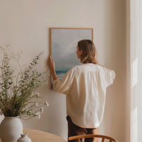 sea painting by clair howlett being hung on wall in dining room - framed sea painting