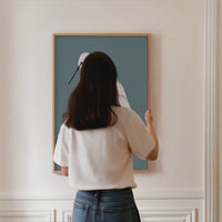 egret heron painting being hung on wall with natural wooden frame. Brid painting hanging on white wall