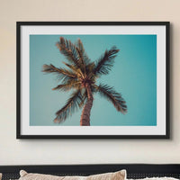 colour photograph of a palm tree against a blue green sky in a neutral bedroom- beach house art