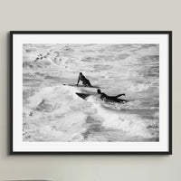 black & white beach art photograph of two surfers in the waves in a black frame above a tidy desk - beach house art