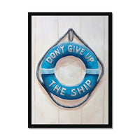 Framed artwork of a blue life buoy with 'Don't Give Up The Ship' text on a light wooden background.