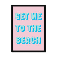 Framed coastal typography print with 'GET ME TO THE BEACH' text on a pink background and black frame.