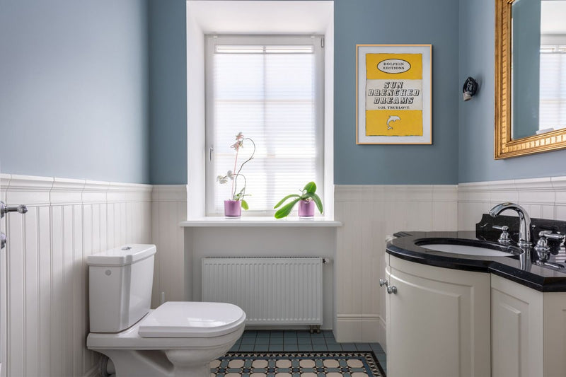 Framed vintage book poster in a small bathroom -  framed colourful bathroom print