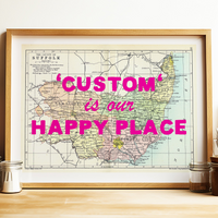 Framed map with 'Custom is our Happy Place' text on a wooden surface.