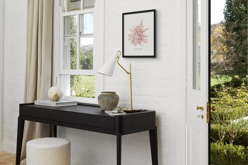 Seaweed pressing art print above console table in hallway