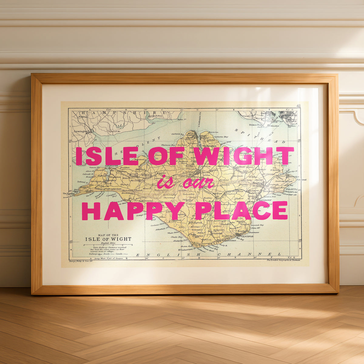 Framed map of isle of wight with 'Isle of wight is our happy place' text on a wall.