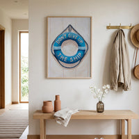 Coastal wall art in a nautical-themed room with a bench, shoes, and decorative items.