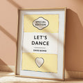 Framed poster with 'Special Edition Let's Dance David Bowie' design on a beige wall.