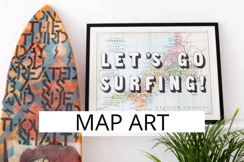 map art print of cornwall with lets go surfing typography printed on top. art surfboard next to art print.