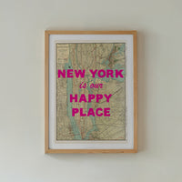Framed map with 'New York is our happy place' text above a bed in a bedroom.