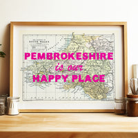 Framed map of Pembroke with 'Pembrokeshire is our happy place' text on a wooden shelf.