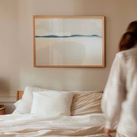 Woman standing by a bed with a abstract painting on the wall