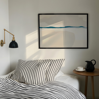 Bedroom with striped bedding, a lamp, and a framed abstract painting on the wall.