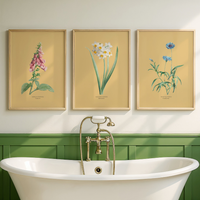 Set of three floral art prints with yellow background in bathroom.