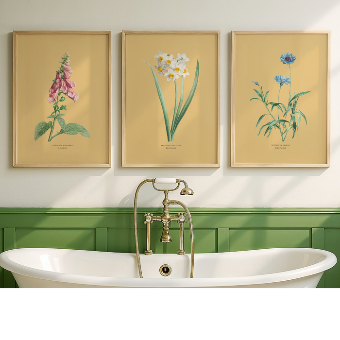 Set of three flower art prints on a yellow background - Bathroom with a freestanding bathtub, gold faucet, and three framed botanical prints on the wall.