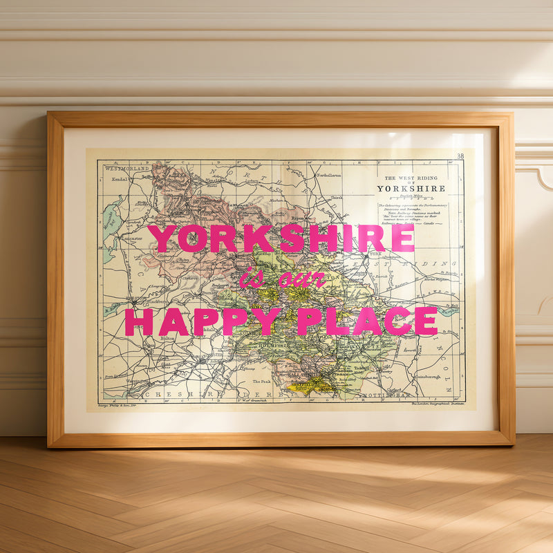 Framed map of Yorkshire with 'Yorkshire is our happy place' text on a wooden floor.