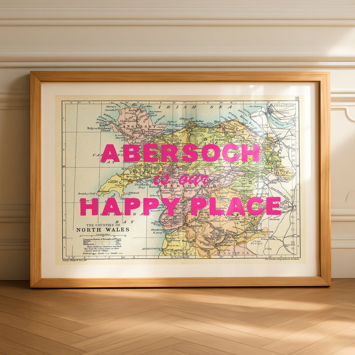 Framed map of Abersoch with 'Abersoch is our happy place' text on a wooden floor.