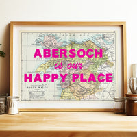 Framed map of Abersoch with 'Abersoch is our happy place' text on a wooden shelf.