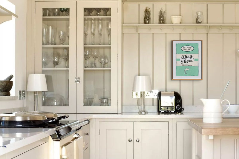 cream wooden country kitchen with wood panelling and vintage book print above toaster