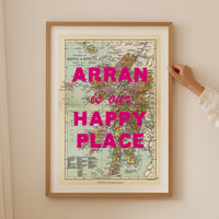 Framed map with 'Arran is our happy place' text on a beige wall.