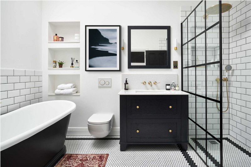 Black and white bathroom photography art print. White metro tiled bathroom with black fixtures and seaside prints for bathroom