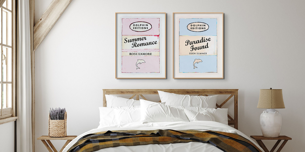 set of two book cover prints framed on wall above bed in bed room - bedroom wall art