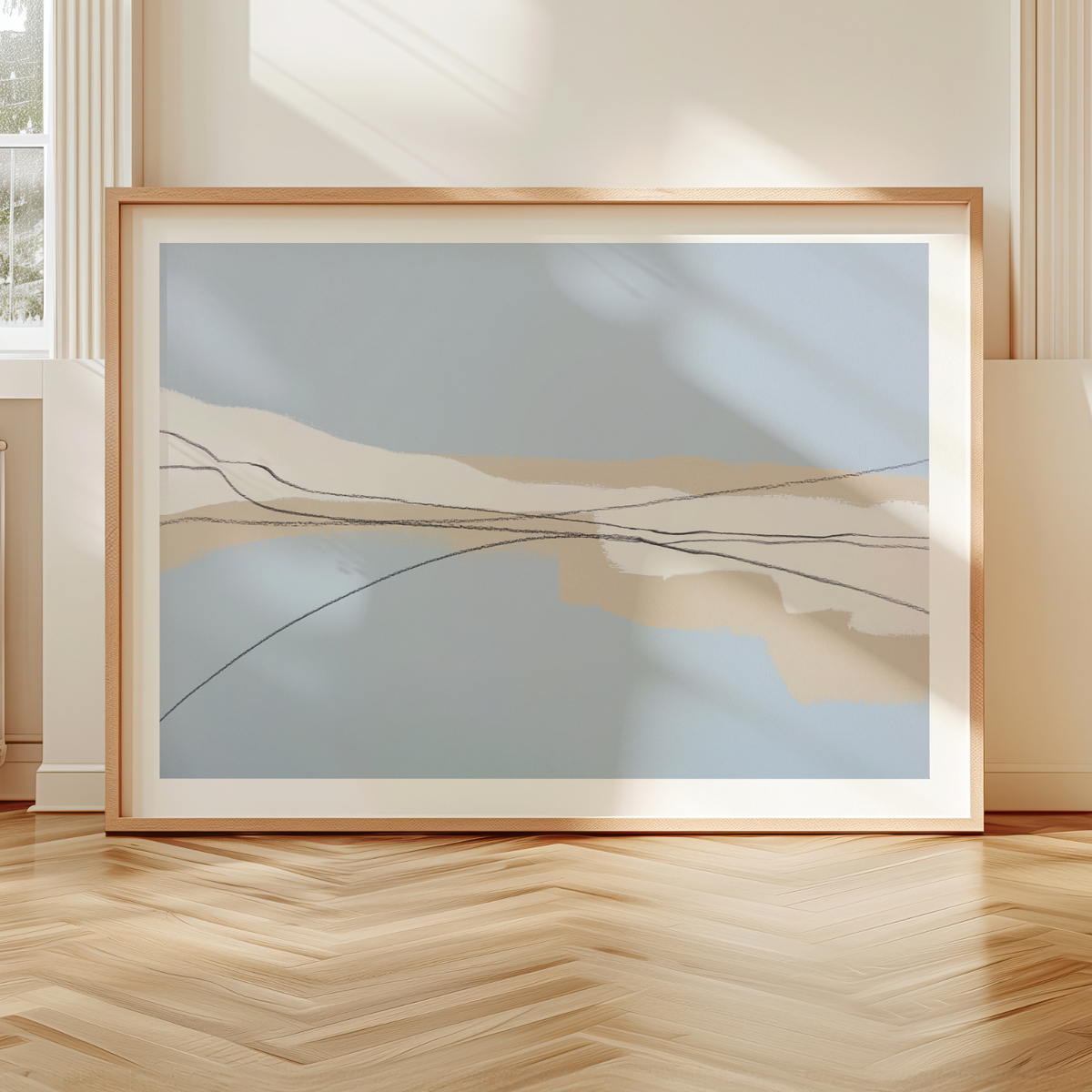 Framed abstract artwork on a wooden floor with a neutral wall background