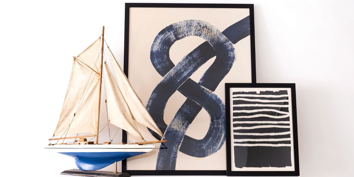 coastal wall art collection header feacturing two coastal picture on shelf next to model boat -framed coastal picutres by beach house art