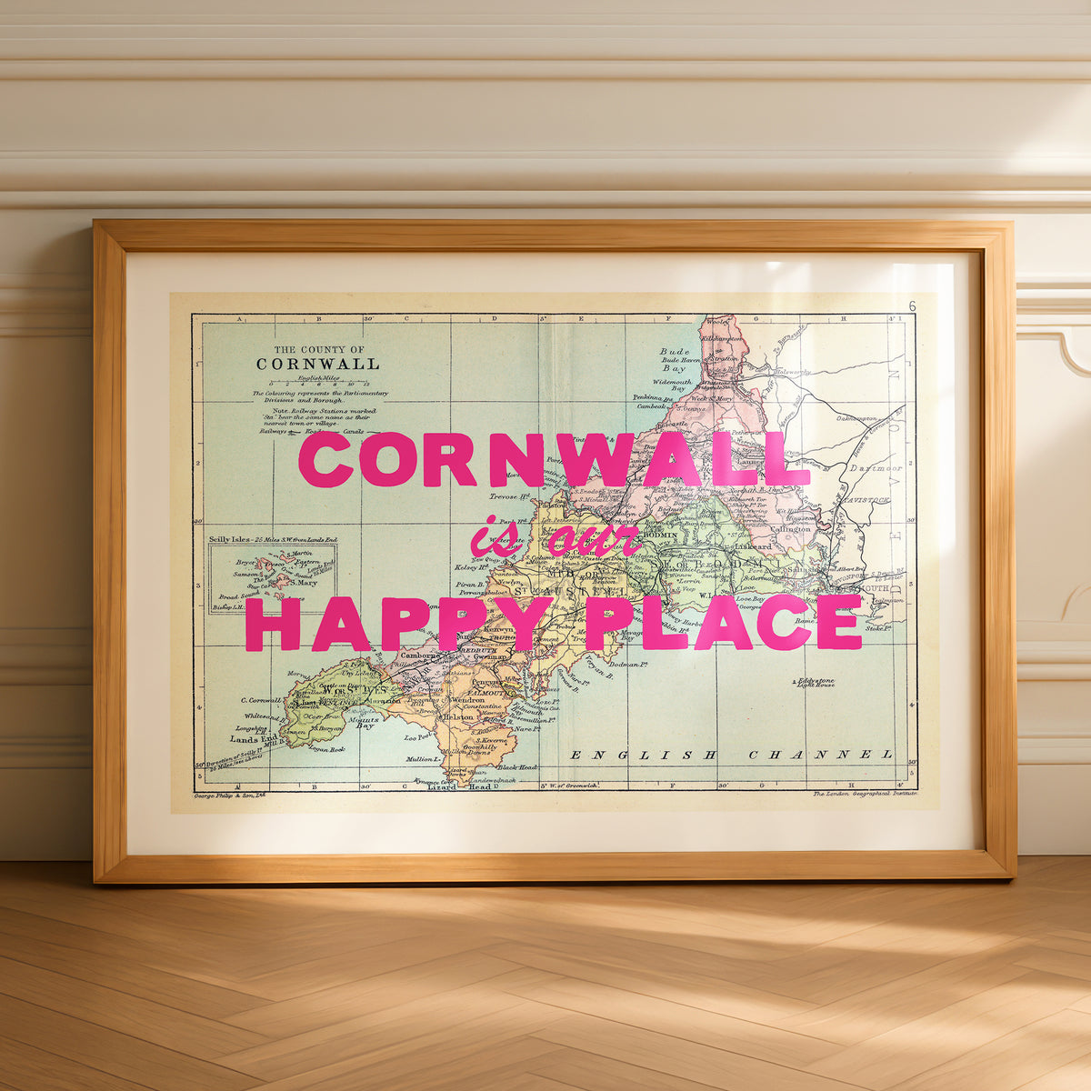 Framed map of Cornwall with 'Cornwall is our happy place' text on a wooden floor.