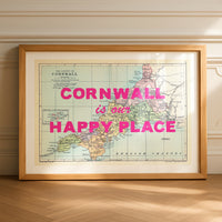 Framed map of Cornwall with 'Cornwall is our happy place' text on a wooden floor.