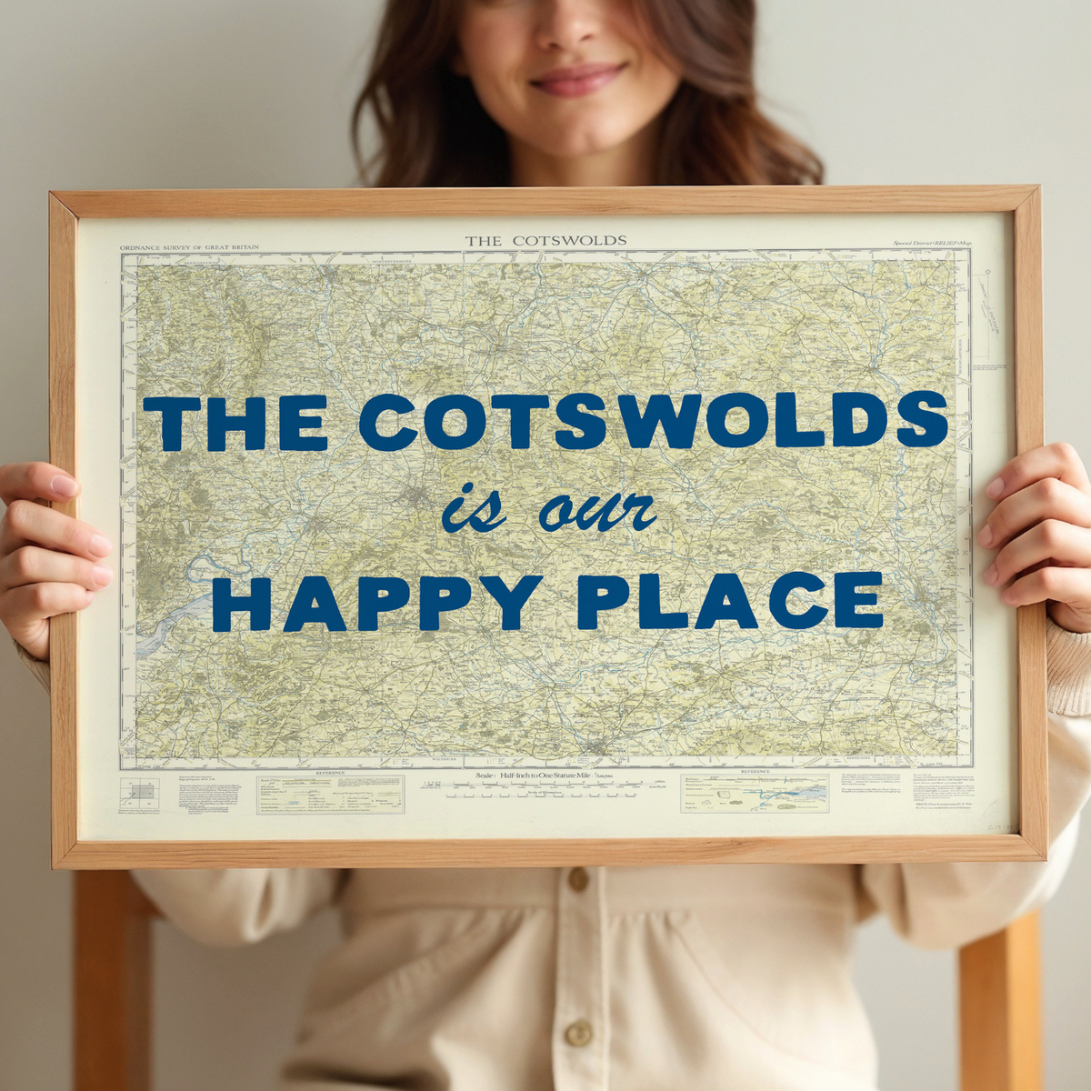 Person holding a framed map of the cotswolds with 'The Cotswolds is our happy place' text.