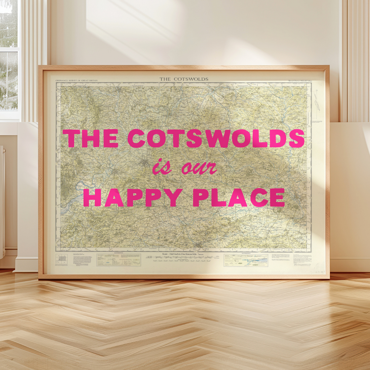 Framed Cotswolds map print with 'The Cotswolds is our happy place' text in a room with wooden flooring.