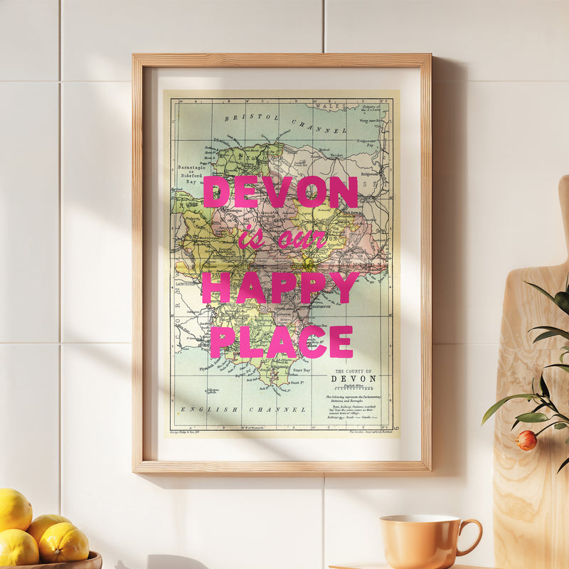 Framed map of Devon with 'Devon is our happy place' text on a wall.