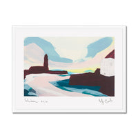 An abstract landscape art print featuring a coastal scene with a tower, cliffs, and a house, presented in a white mat and frame against a white background.