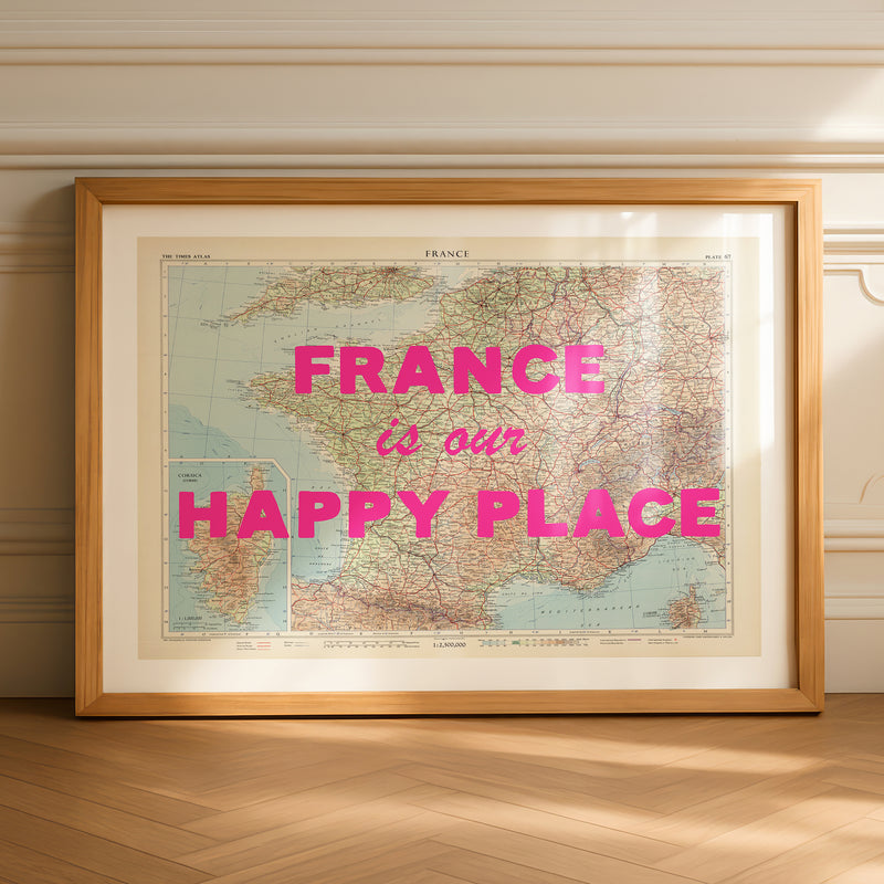Framed map of France with 'France is our happy place' text on a wooden floor.