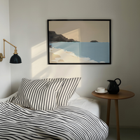 Bedroom with striped bedding, a side table with a pitcher and cup, and a framed seascape print on the wall.