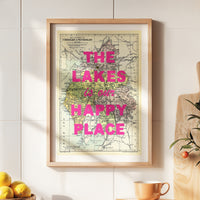 Framed map with 'The Lakes is our happy place' text on a wall.