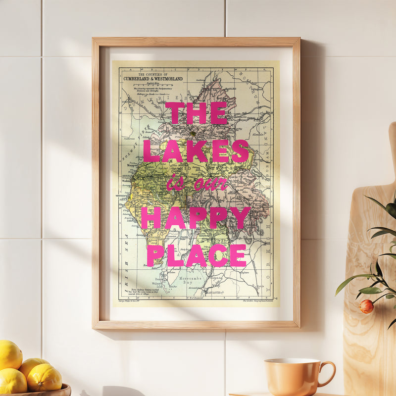Framed map with 'The Lakes is our happy place' text on a wall.