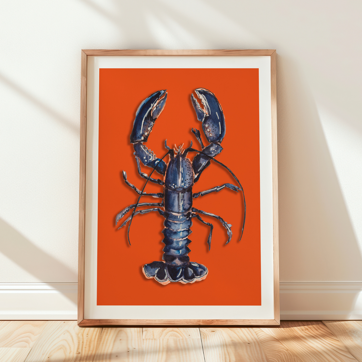 Framed artwork of a blue lobster on an orange background - colourful kitchen art print