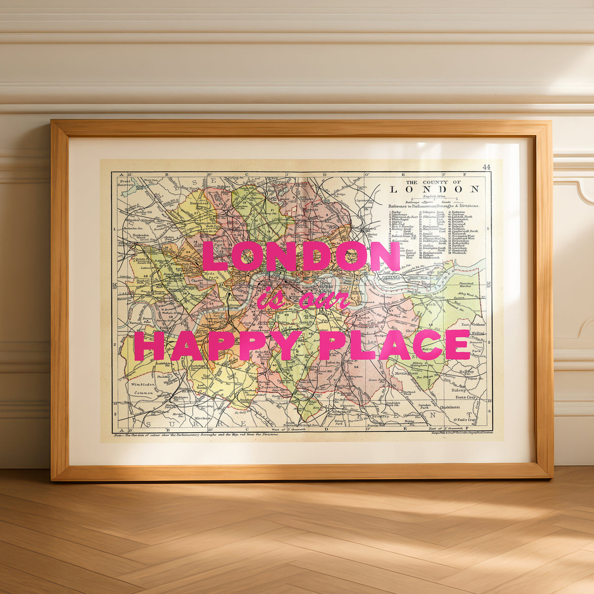 Framed map of London with 'London is our happy place' text on a wooden floor.