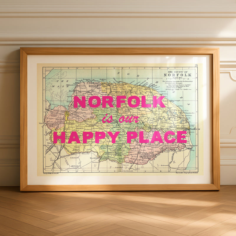 Framed map of Norfolk with 'norfolk is our happy place' text on a wall.