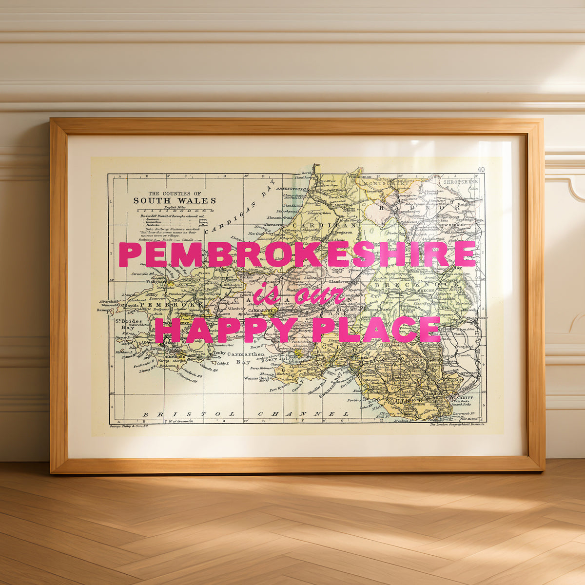 Framed map of Pembrokeshire with 'Pembrokeshire is our happy place' text on a wooden floor.