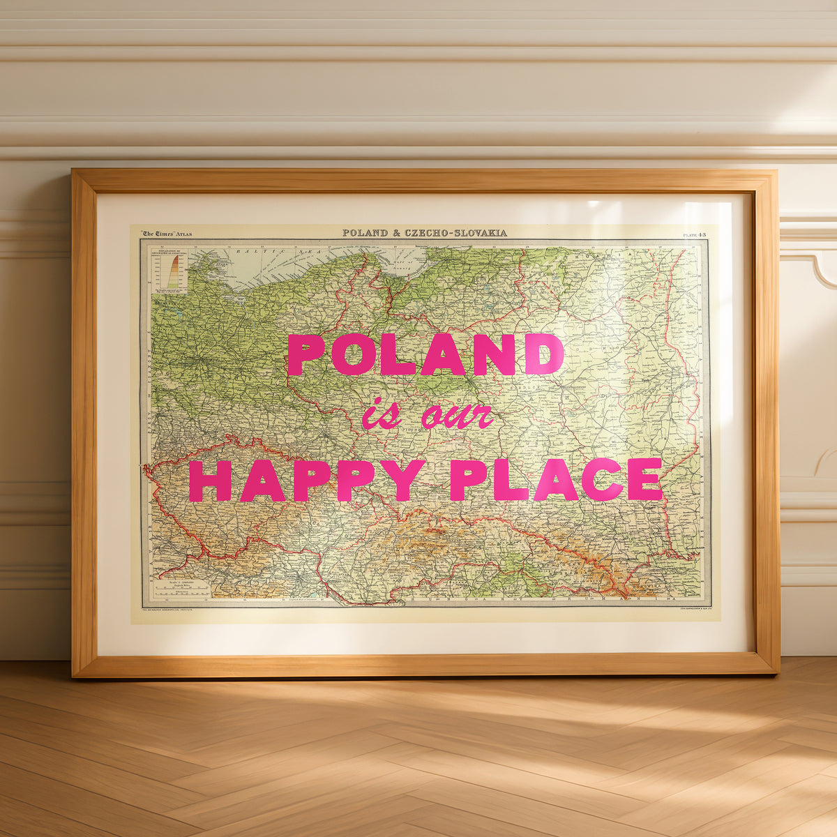 Framed map of Poland with 'Poland is our Happy Place' text on a wooden floor.