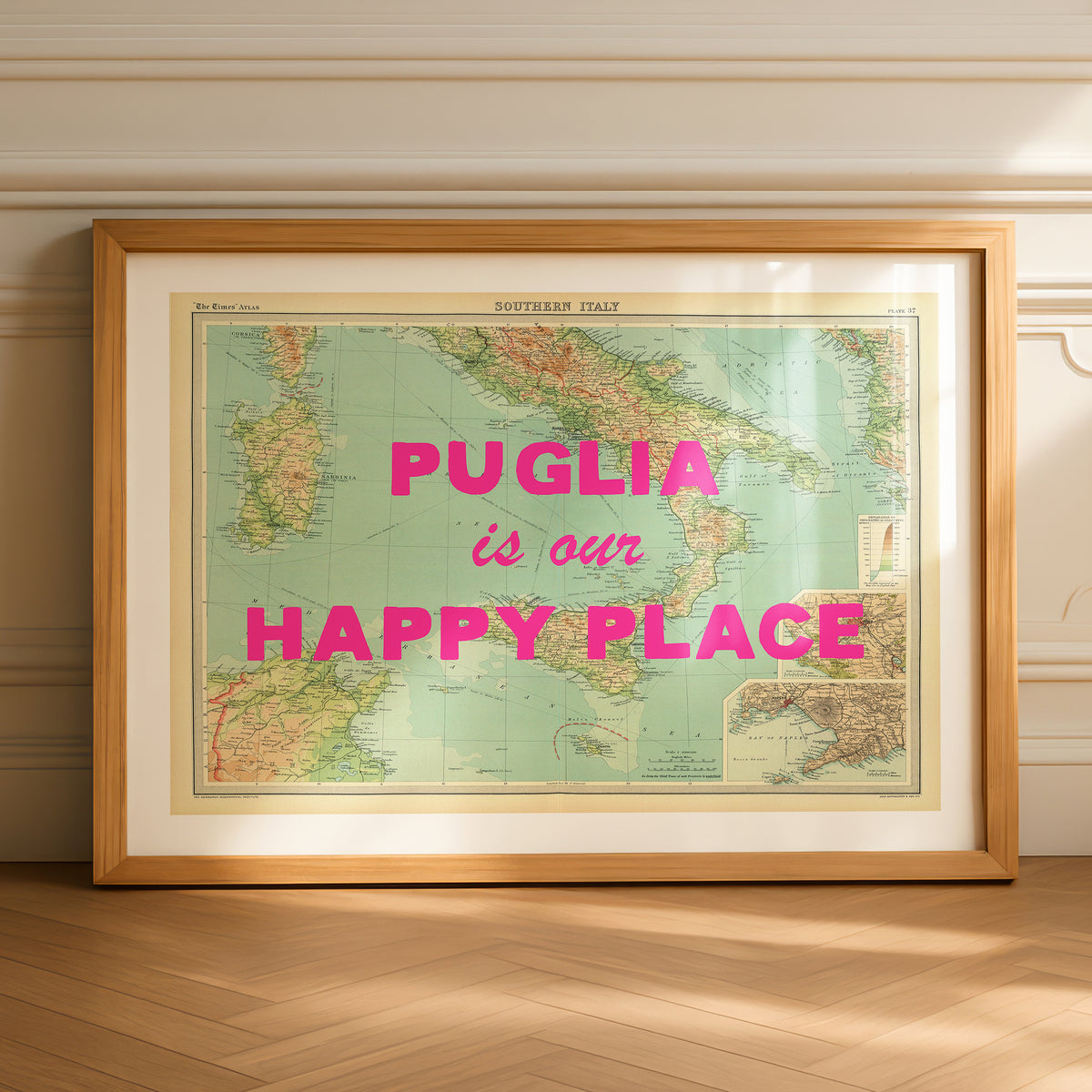 Framed map of Italy with 'Puglia is our happy place' text on a wooden floor.