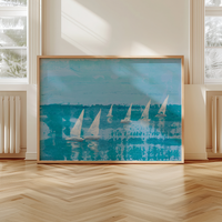 Framed artwork of sailboats on a blue background in a room with large windows.