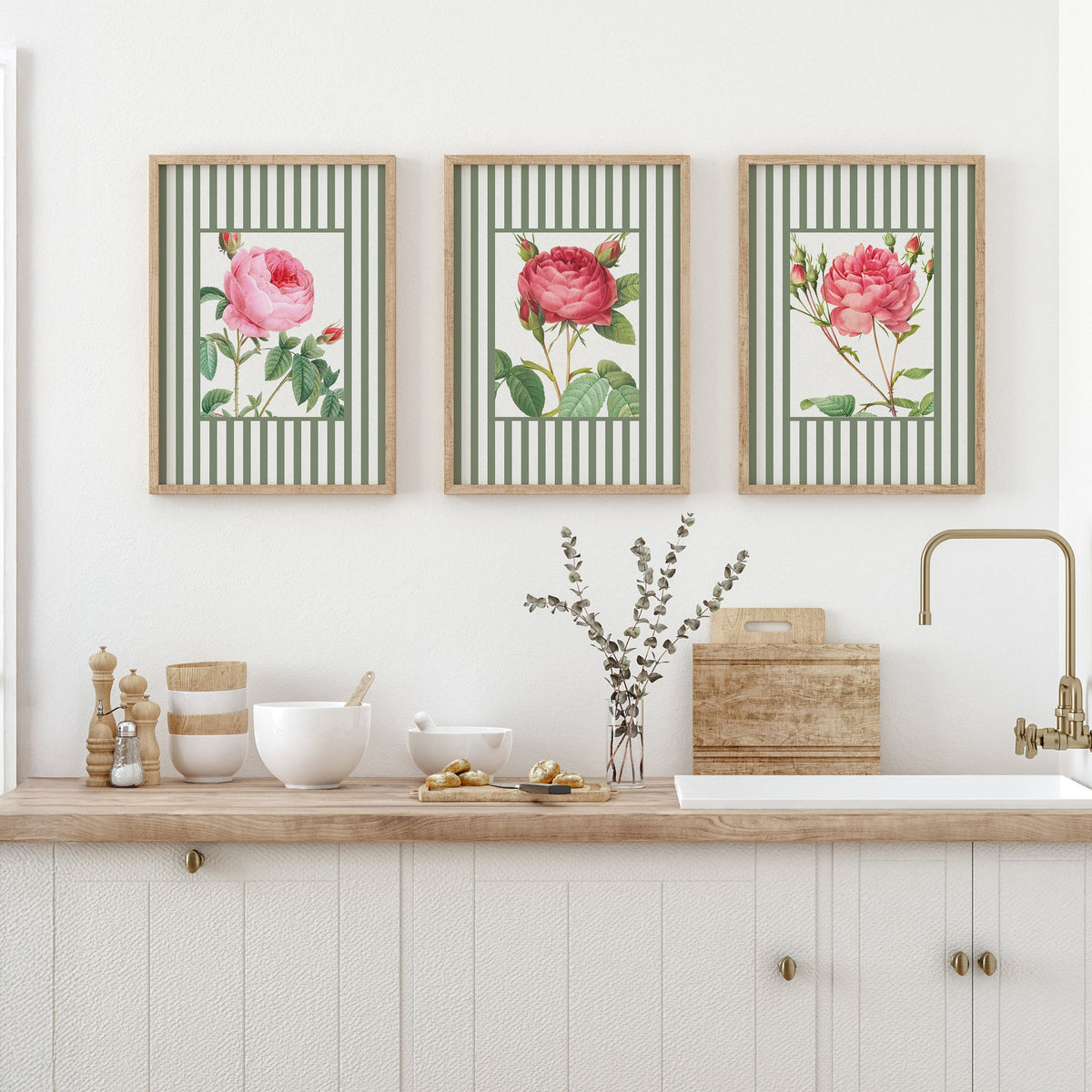 Three framed floral prints above a kitchen counter with various items.