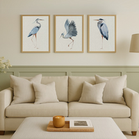set of three heron art prints in living room above sofa