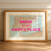 Framed map of Spain with 'Spain is our happy place' text on a wooden floor.
